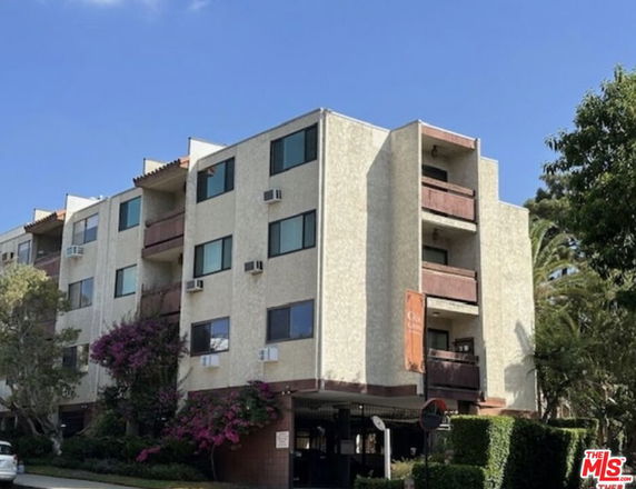 Front view of a multi-story apartment building with balconies.