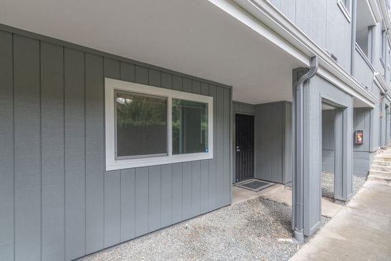 Front view of a building with gray paneling and a covered entrance.