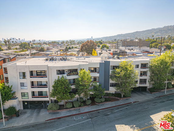 Front view of a multi-story building with surrounding greenery.