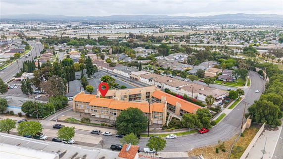 Aerial view of a neighborhood with numerous houses and a large building with an orange roof.