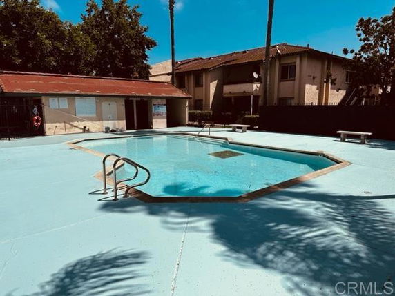 Outdoor swimming pool area with a small building nearby.