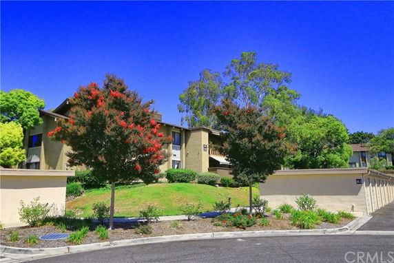Front view of a two-story building with surrounding trees and greenery.