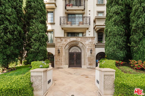 Front view of a multi-story building with an ornate entrance and balconies.