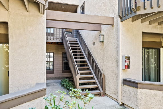 Front view of a building with an outdoor staircase leading to the upper floor.
