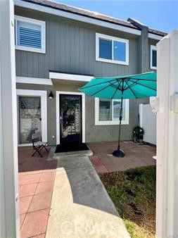 Front view of a two-story house with a small patio area.