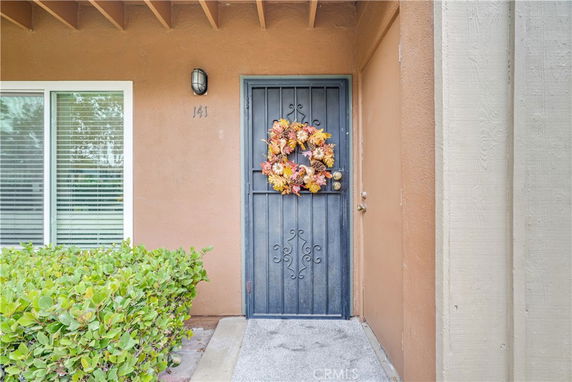 Front view of a house entrance with a decorative wreath on the door.