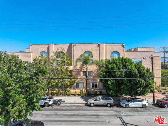 Front view of a multi-story building with large arched windows.