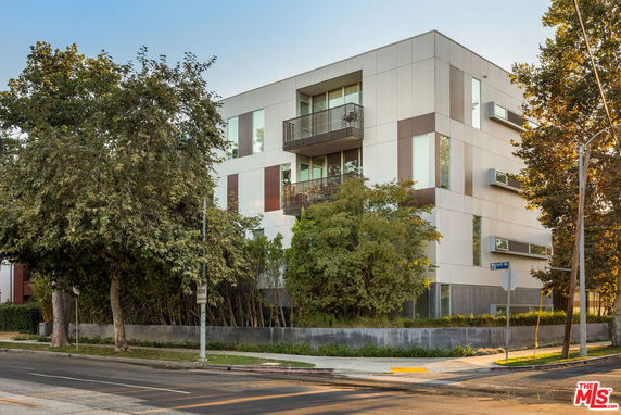 Front view of a modern multi-story building with large windows and balconies.