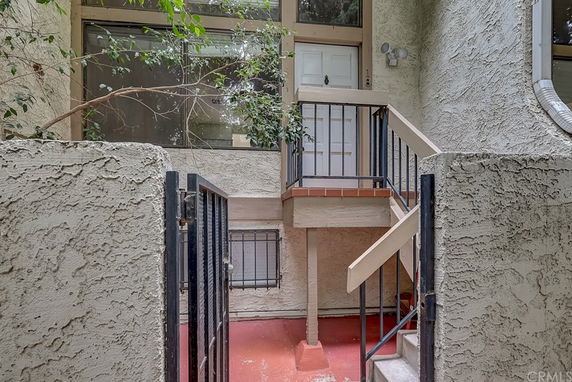Entrance of a residential building with stairs leading to a door.