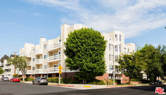 Front view of a multi-story apartment building with balconies.