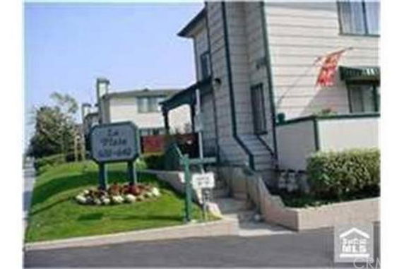 Front view of a two-story residential building with a sign in front.