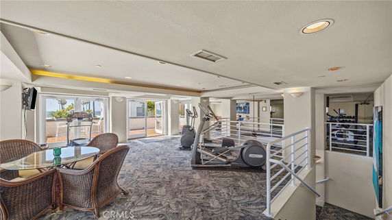 Interior view of a recreation area with gym equipment and seating.