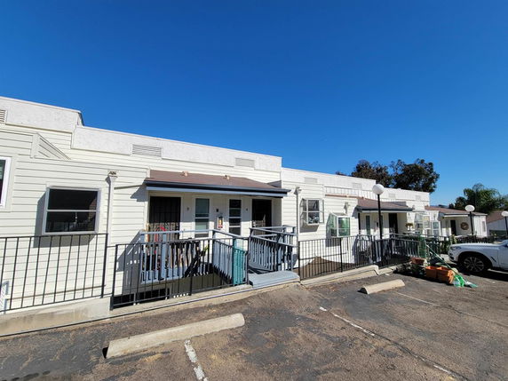 Front view of a row of single-story buildings with ramps and railings.