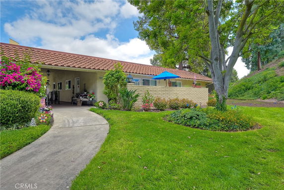 Front view of a single-story house with a tiled roof and garden area.