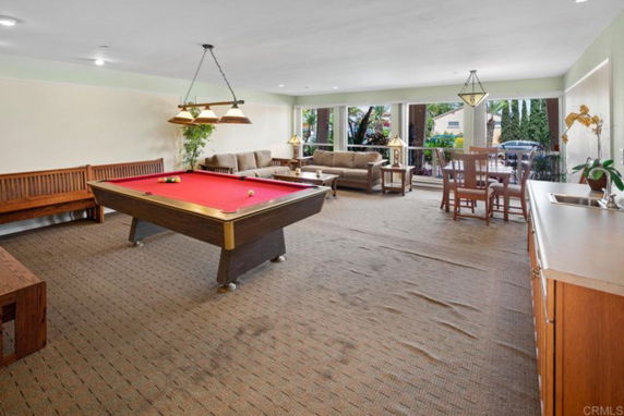 Recreation area with a pool table and seating, featuring a cozy interior.