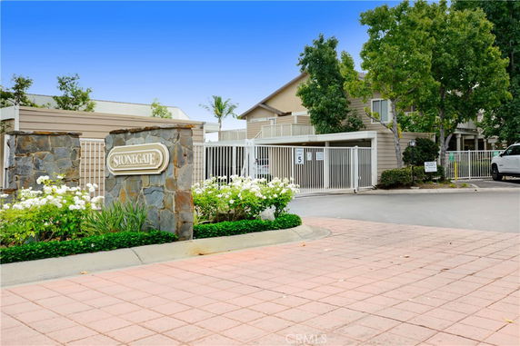 Front view of a residential building with gated entrance and name plaque.