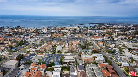 Panoramic view of coastal city with residential buildings and ocean in the background.