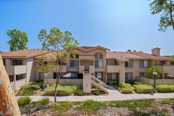 Front view of a two-story residential building with a tiled roof and balconies.