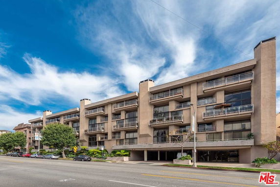 Front view of a multi-story apartment building with balconies.