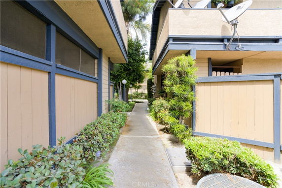 Pathway between buildings with beige and blue trim.