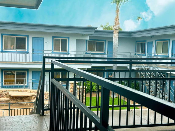 View from an upper level of a building overlooking a courtyard with blue doors and windows.