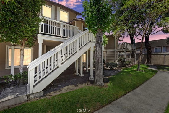 Front view of a two-story house with exterior staircase and balconies.