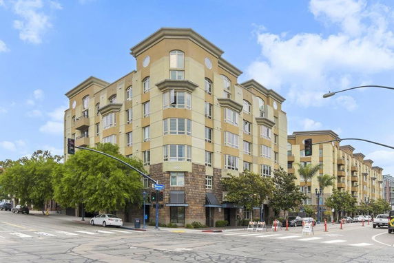 Front view of a multi-story apartment building on a street corner.