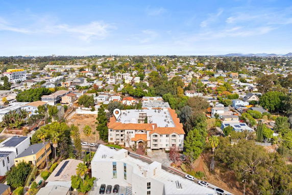 Aerial view of a residential area with a prominent multi-story building with orange roofs.