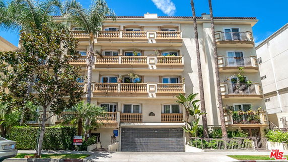 Front view of a multi-story apartment building with balconies.