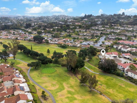 Aerial view of a suburban area with houses and a surrounding golf course.