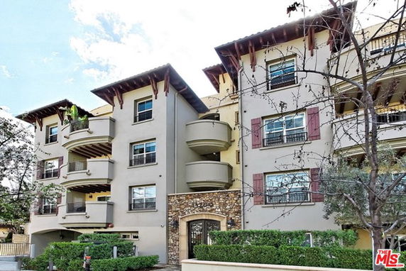 Front view of a multi-story apartment building with balconies and stone accents.
