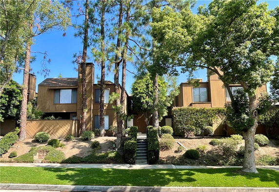 Front view of a multi-story house surrounded by trees.