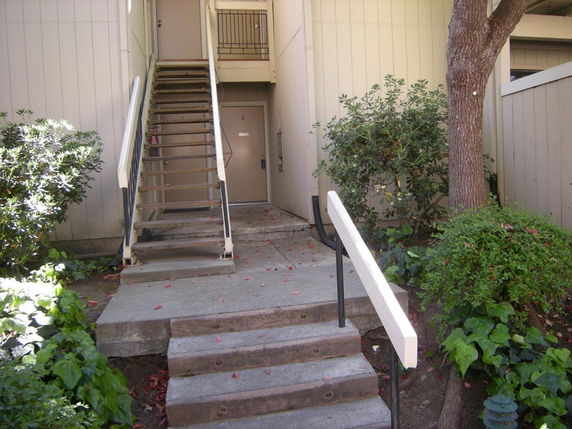Front view of a building entrance with stairs leading to an upper level.