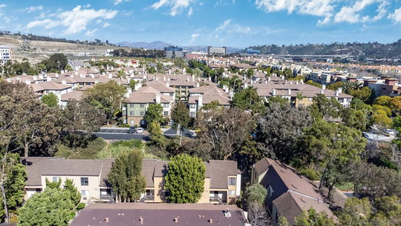 Panoramic view of a residential area with multiple buildings and surrounding landscape.