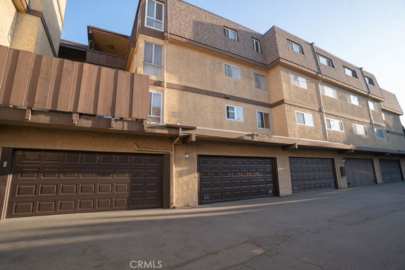 Front view of a multi-story residential building with multiple garage doors.