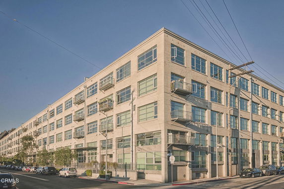 Front view of a four-story building with large windows and balconies.