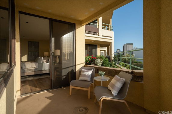 Seating area on a balcony overlooking surrounding buildings.