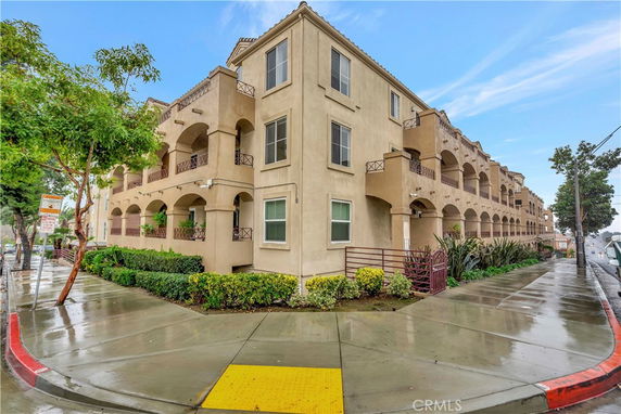Front and side view of a multi-story residential building with balconies.
