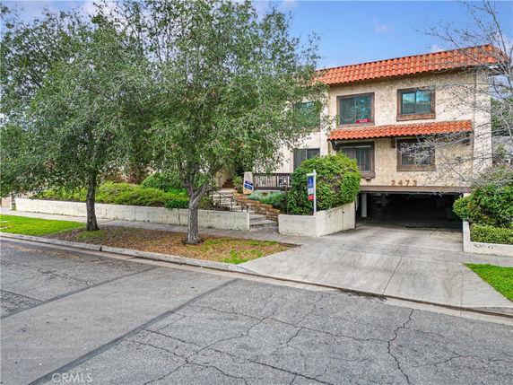 Front view of a two-story building with a tiled roof and a garage area.