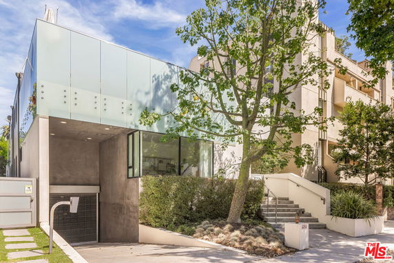 Front view of a modern two-story building with a glass exterior and concrete elements.