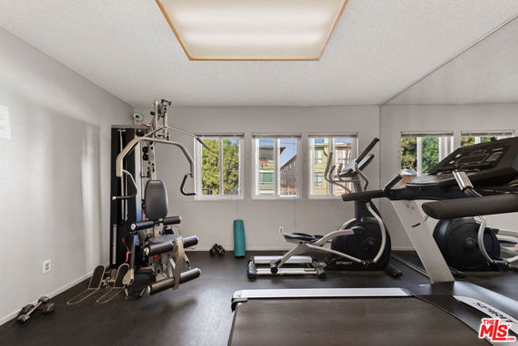 Indoor gym area with exercise equipment including a treadmill and weight machine