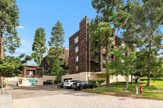 Front view of a multi-story residential building with brick facade and balconies.