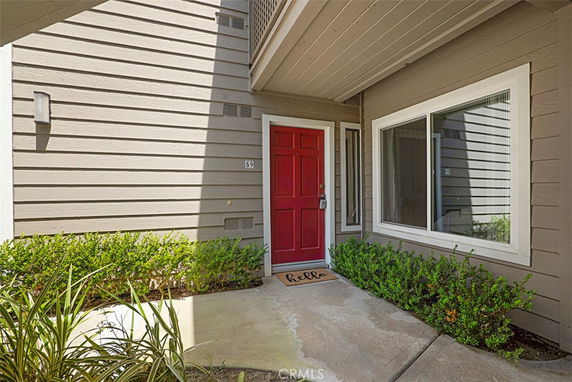 Front view of a house with a red front door and adjacent window.