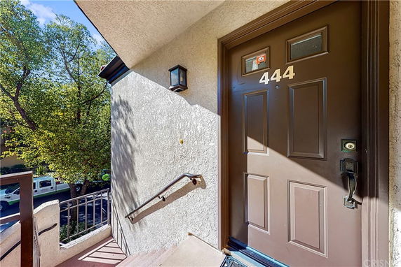 Entrance view of a building with a brown door labeled 444.