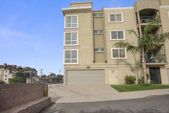 Front view of a multi-story residential building with a garage.