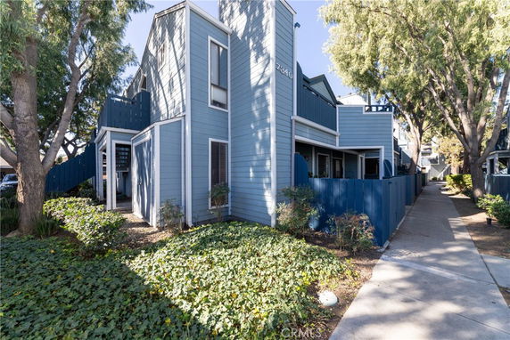 Front view of a multi-level residential building with blue siding.