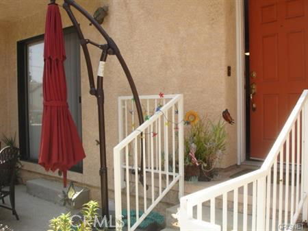 Front view of a house entrance with steps and a red door.