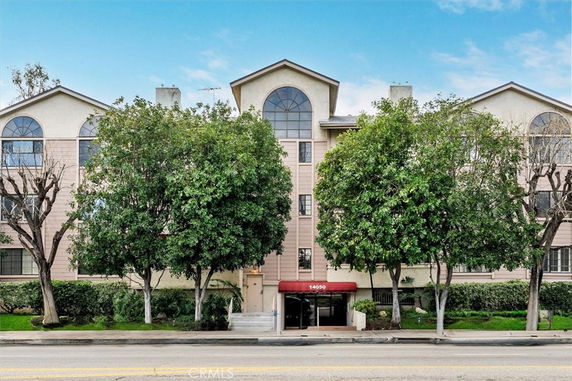 Front view of a multi-story residential building with arched windows.