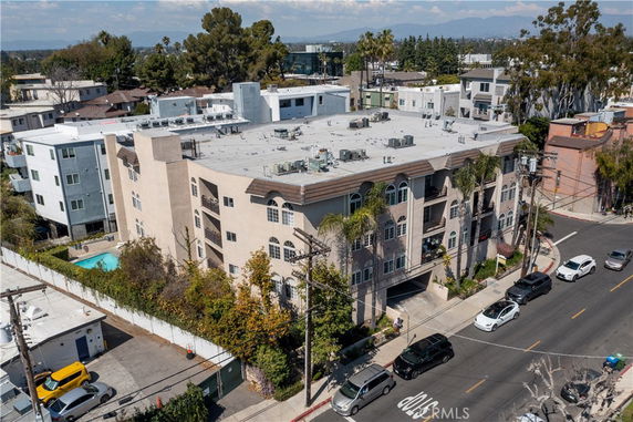 Front view of a multi-story apartment building on a street corner.