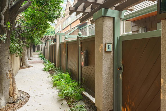 Front view of a building with wooden gates and concrete pillars along a pathway.